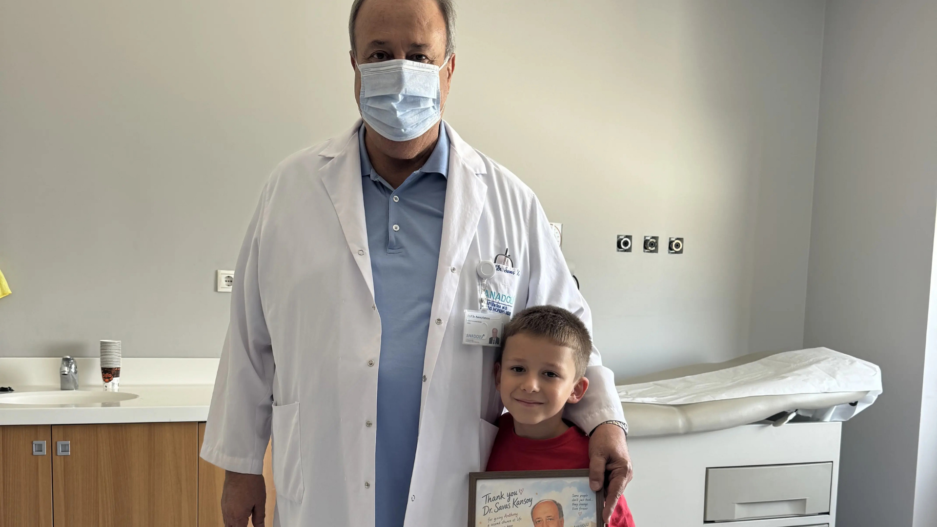 Micuțul Antony vindecat și zâmbitor în brațele părinților săi după transplantul reușit.