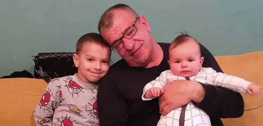 Миле Бежовски од Охрид насмеан додека си игра и ги прегрнува своите внуци за време на семеен момент исполнет со љубов и блискост.