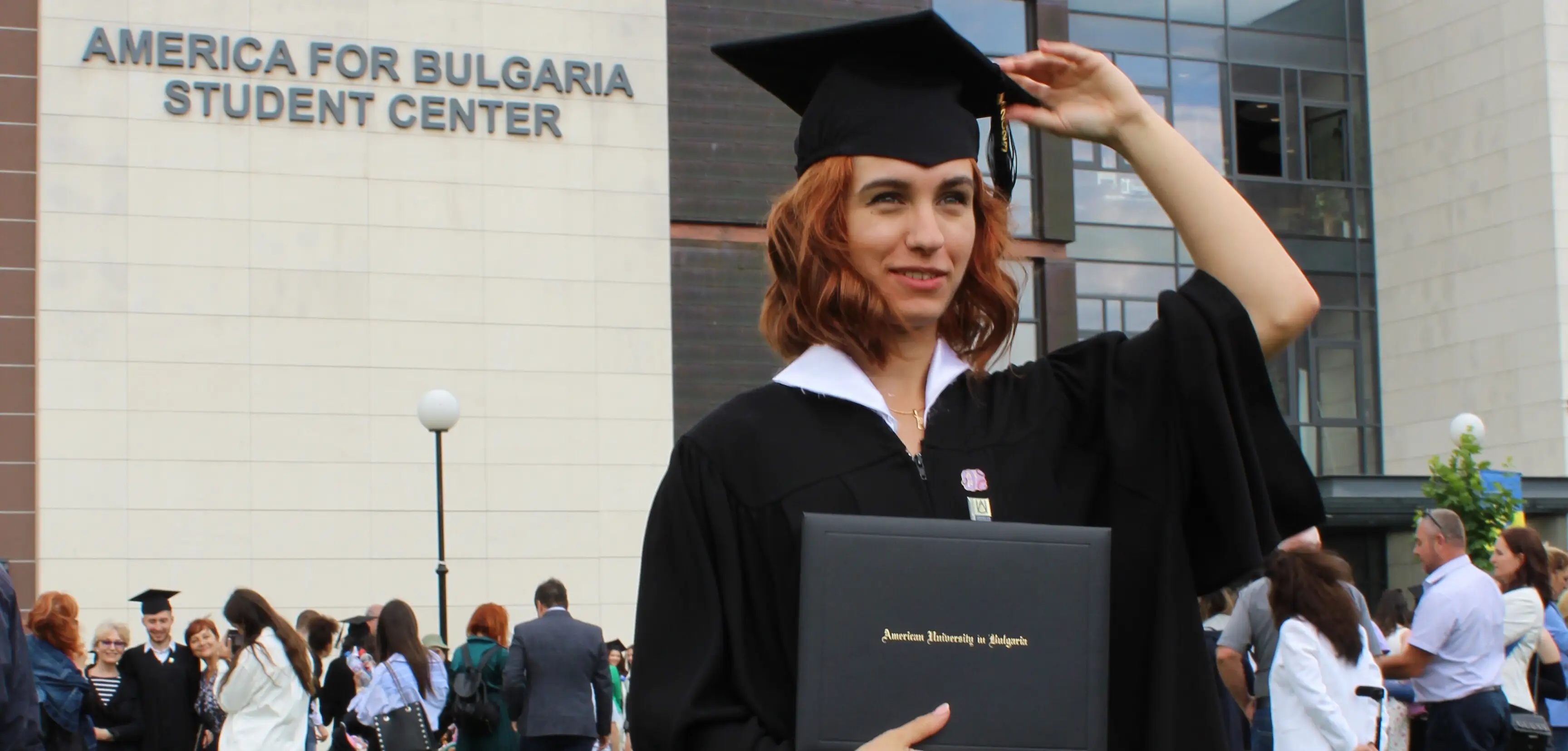 Monika în ținută de absolvire, zâmbitoare după campania de succes prin care a obținut sprijin pentru studiile de jurnalism la UC Berkeley prin PavelAndreev.ORG
